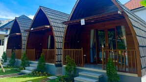 Una hilera de cabañas pequeñas y modernas con techos inclinados y balcones de madera.