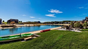 Vista para o lago com barcos, um pátio e casas.