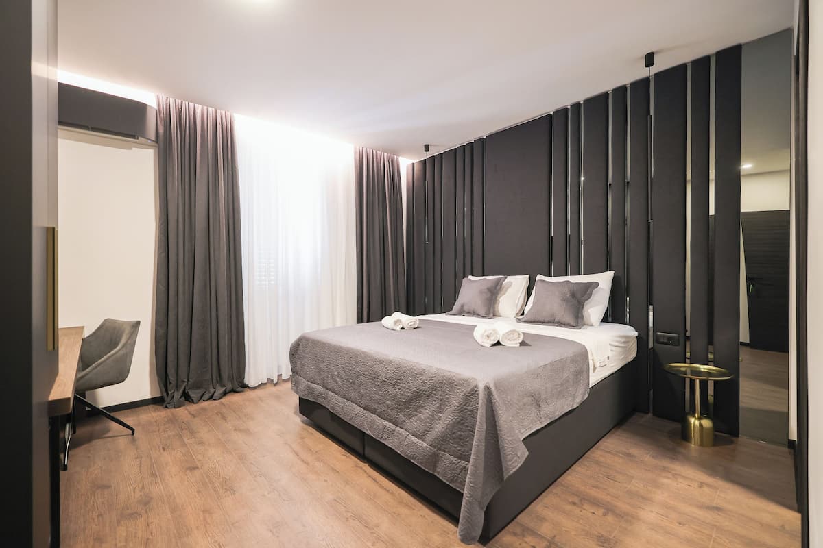 Une chambre moderne avec un grand lit, un bureau et une chaise.