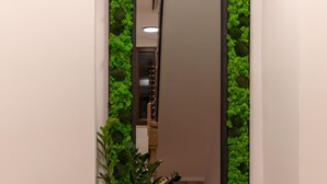 Eine Ecke mit Spiegel, Topfpflanze und Holzboden.