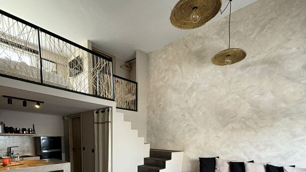 A modern living space with a kitchen, dining area, and a staircase leading to an upper level. - Stella's Loft In Center Of Tinos (Tinos)