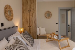 Un dormitorio con cama, mesita de noche, lámpara y un armario de madera.