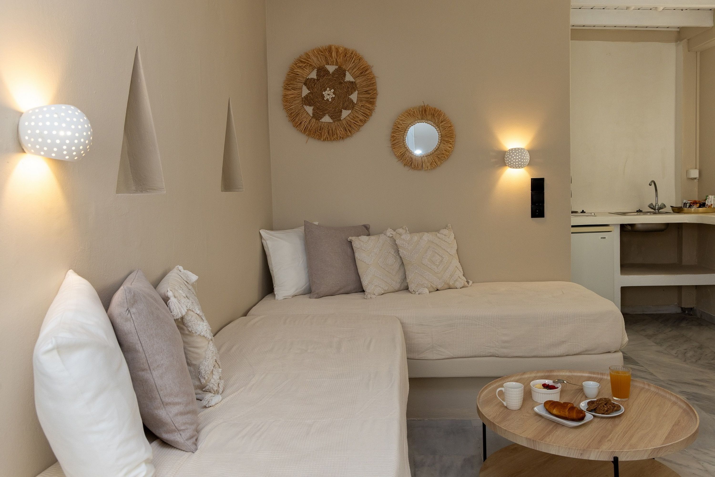 Un dormitorio moderno con dos camas, una mesa redonda para desayunar y decoración en la pared.