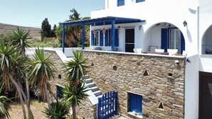 Un bâtiment blanc avec des volets bleus et une façade en pierre.