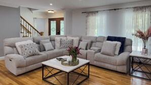 A living room with a sectional sofa, a coffee table, and a small side table.