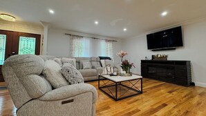 A living room with a grey sofa, a coffee table, and a fireplace.