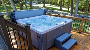A hot tub on a wooden deck with steps leading up to it.