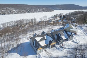 A residential area with multiple houses, some with snow-covered roofs, surrounded by a snowy landscape and trees. - Modern Dog Friendly Mountain Retreat w/ Hot Tub (Oakland)