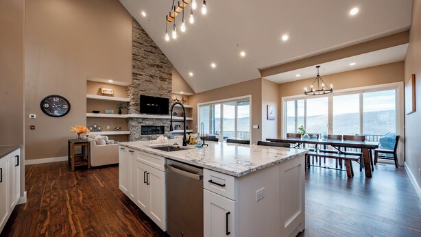 Una cocina amplia con una isla grande, un muro decorativo de piedra y un comedor con vistas.