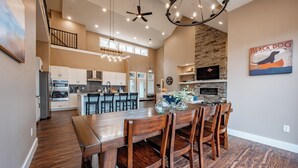 Una cocina amplia con una isla central, un comedor con muebles de madera y una pared decorativa de piedra.