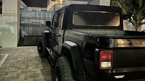 Un SUV negro estacionado frente a un edificio con un letrero que dice "South Beach Residence".