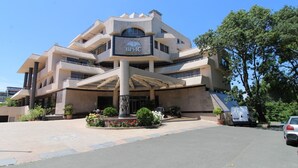 A modern building with a central entrance, multiple balconies, and a sign reading "ВРИС АРТЕСТКОТЕА". - Menada Vris Apartments (Tsarevo)