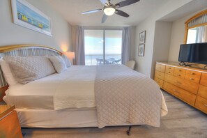 A hotel room with a bed, a ceiling fan, a TV, and a view of the ocean. - Spacious Oceanfront 3BR 3BA at Crescent Shores - Pools, Lazy River & Stunning Views (North Myrtle Beach)