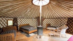A cozy interior of a yurt with a bed, a table, and a chair. - Cévennes yurt (Malons-et-Elze)