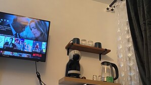 A kitchen with a microwave, a coffee maker, and a shelf with cups. - Beautiful, quiet studio near Vichy (Saint-Rémy-en-Rollat)