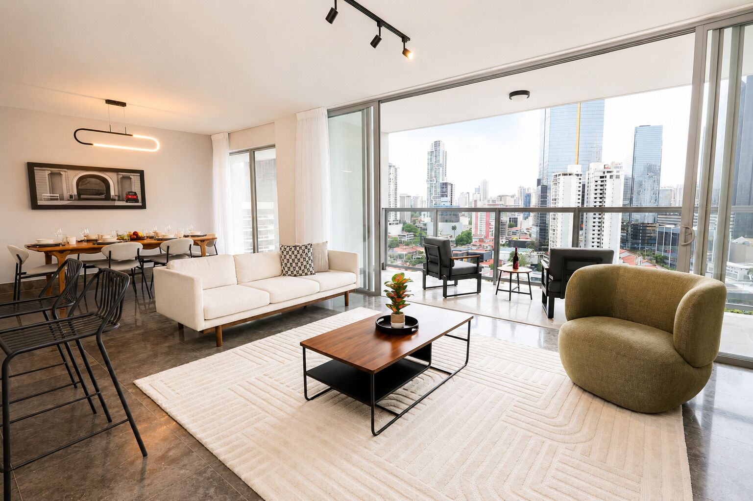 A modern living room with a sofa, coffee table, and chairs, a dining area with a table and chairs, and large windows offering a city view.