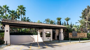 A gated entrance with a covered waiting area, palm trees, and a sign reading "La Medina de Banus". - Stylish Apartment With Pool in Marbella - Ref M51 (Marbella)
