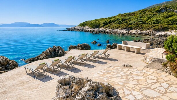 A coastal terrace with lounge chairs, a stone deck, and a view of the sea and hills. - Villa Pelagos Kyma - Two Bedroom Villa, Sleeps 4 (Lefkada)