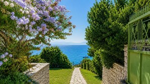 A stone pathway leading to a view of the sea, flanked by greenery and a stone wall. - Villa Pelagos Kyma - Two Bedroom Villa, Sleeps 4 (Lefkada)