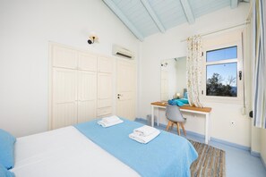 A bedroom with a bed, a desk, a chair, a window with curtains, and a ceiling fan. - Villa Anemus - Three Bedroom Villa, Sleeps 6 (Lefkada)