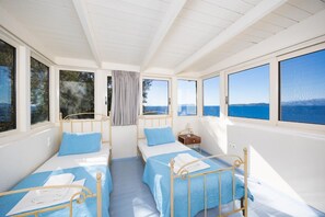 A room with two beds, large windows, and a view of the sea. - Villa Anemus - Three Bedroom Villa, Sleeps 6 (Lefkada)
