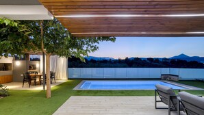 Eine moderne Außenpatio mit Pool, Holz-Pergola und Essbereich.