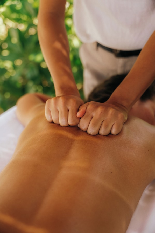 A close-up of hands performing a massage on a person's back. - KYMAIA Hotel Puerto Escondido (Santa Maria Colotepec)