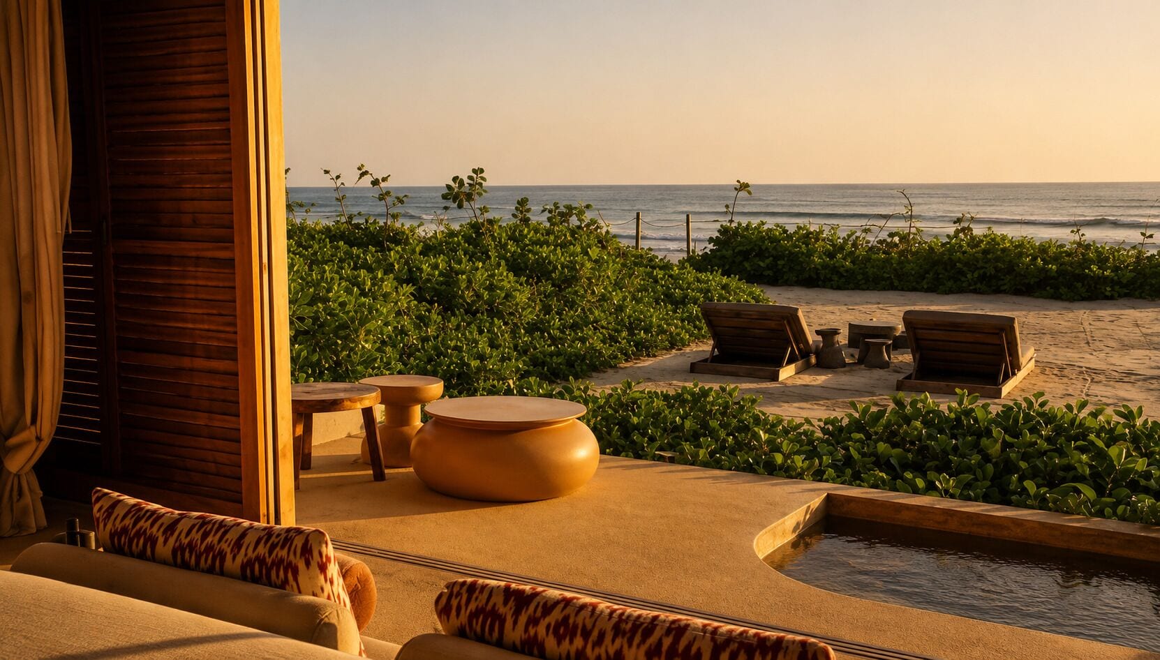 Un área de descanso frente a la playa con asientos y piscina, con vista al océano.