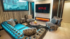 A modern living room with a sofa, chairs, a coffee table, and a fireplace.