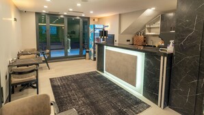 A modern kitchen with a marble countertop, a coffee machine, and a view of the outdoor area.