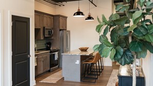 A modern kitchen with wooden cabinets, stainless steel appliances, and a central island with bar stools.