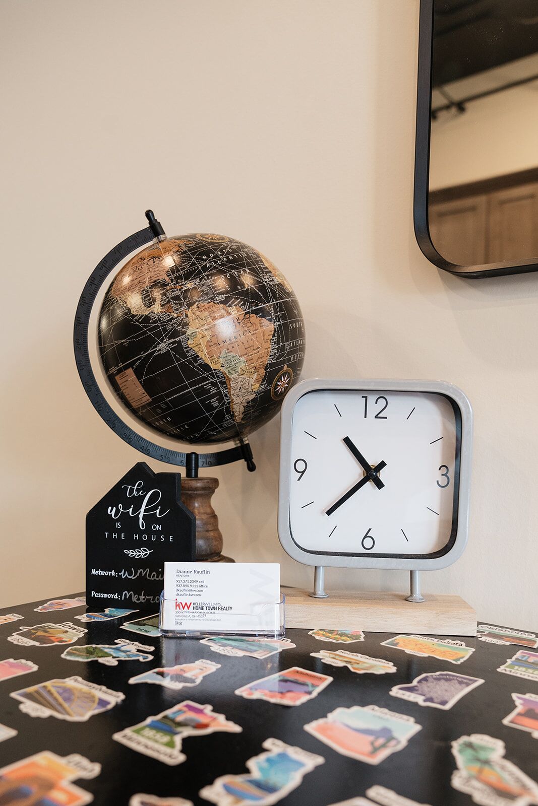 A globe, a clock, and a sign with a WiFi message on a table.