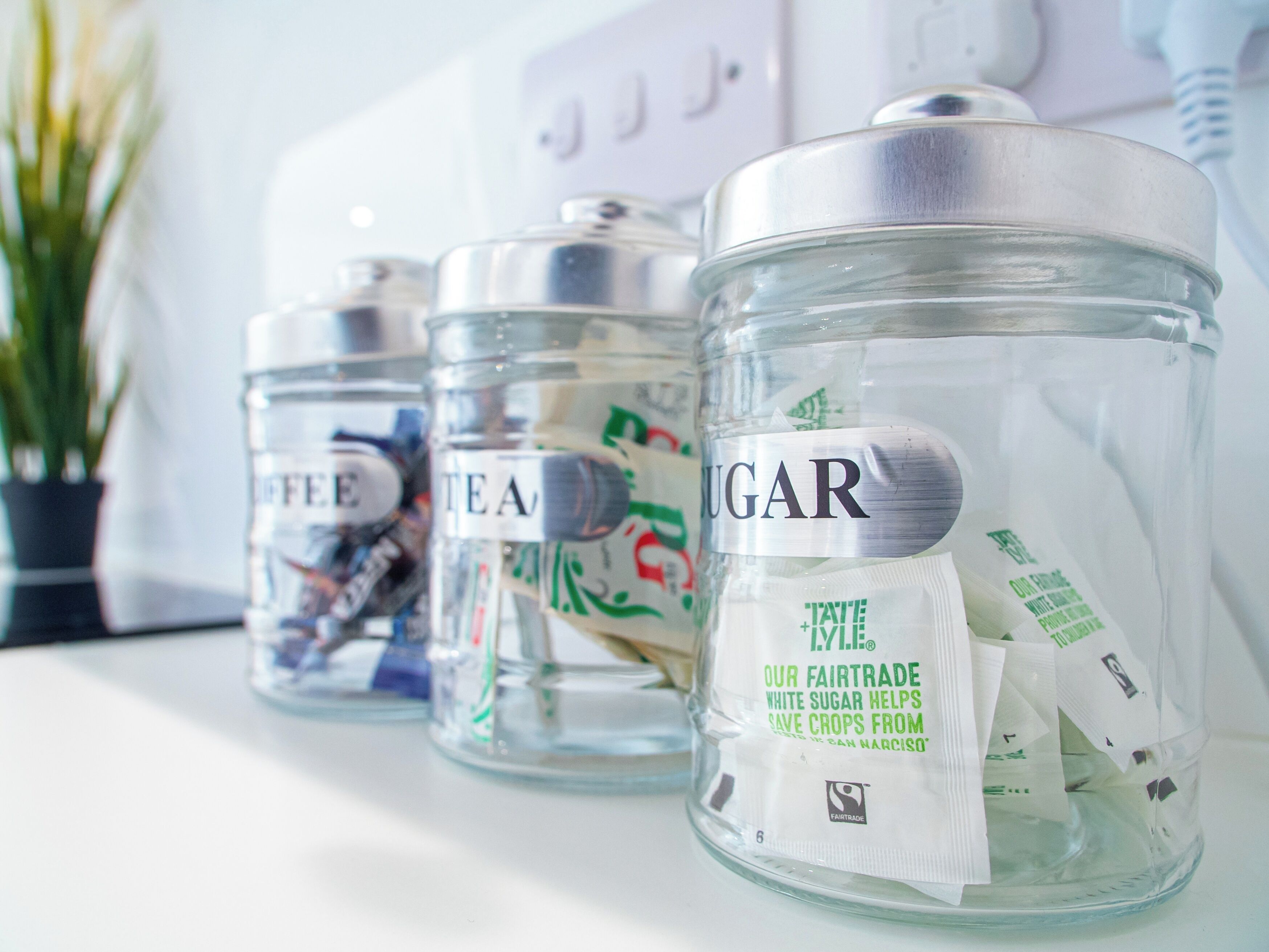 Three glass jars labeled with different contents on a white surface.