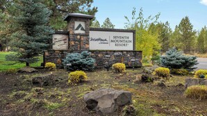 A sign for Seventh Mountain Resort with a stone and wood structure, surrounded by landscaped greenery and trees. - Mount Bachelor Ski Condo w/Hot Tub & Pool Sleeps 6 (Bend)