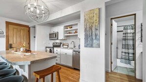 A modern kitchen with white cabinets, stainless steel appliances, and a wooden island with bar stools. - Mount Bachelor Ski Condo w/Hot Tub & Pool Sleeps 6 (Bend)