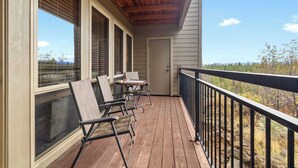 A wooden deck with a railing, a door, and a table with chairs. - Mount Bachelor Ski Condo w/Hot Tub & Pool Sleeps 6 (Bend)