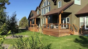 Une maison à deux étages avec une terrasse et un porche couvert.