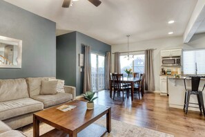 Una sala de estar moderna con un sofá, una mesa de centro y un comedor con sillas y una mesa.