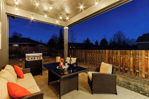 An outdoor patio with wicker furniture, a barbecue grill, and a table set for dining. - 4BR Bend Home Near Mt Bachelor and River Trails (Bend)