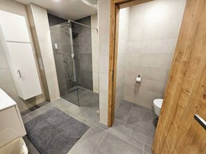 Een douche, handdoeken, toiletpapier