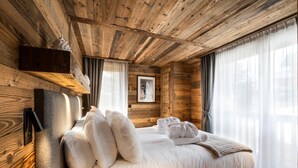 Una camera da letto in stile baita con un letto, cuscini e asciugamani.