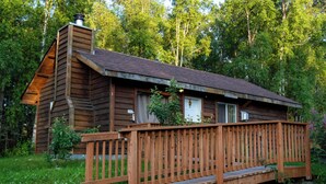 A wooden cabin with a wooden deck and a chimney. - Quaint Rural Cabin Near Hatcher Pass (Wasilla)