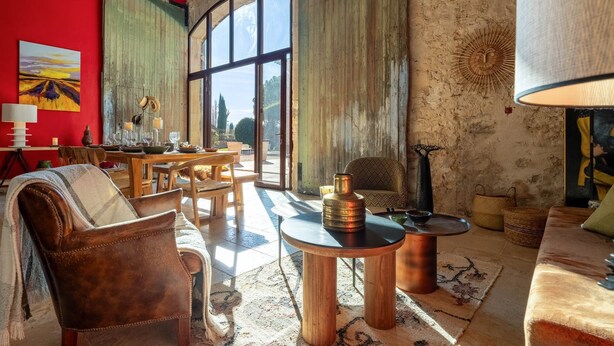 Un saló acollidor amb una finestra gran, decoració rústica i una zona de seients confortable.