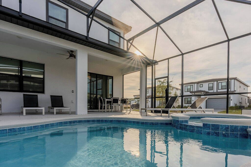 A modern house with a swimming pool, covered patio, and large windows.