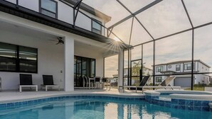 A modern house with a swimming pool, covered patio, and large windows.