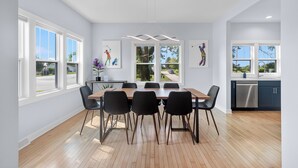 Una cocina moderna con una mesa y sillas de madera, ventanas amplias y vistas al exterior.