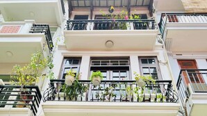 Un edificio de varios pisos con balcones decorados con plantas en macetas.