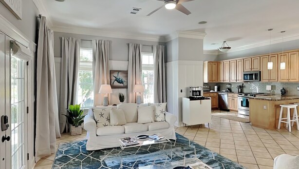 A spacious living room with a white sofa, a coffee table, and a kitchen in the background. - Paradise Escape by Southern Vacation Rentals (Destin)
