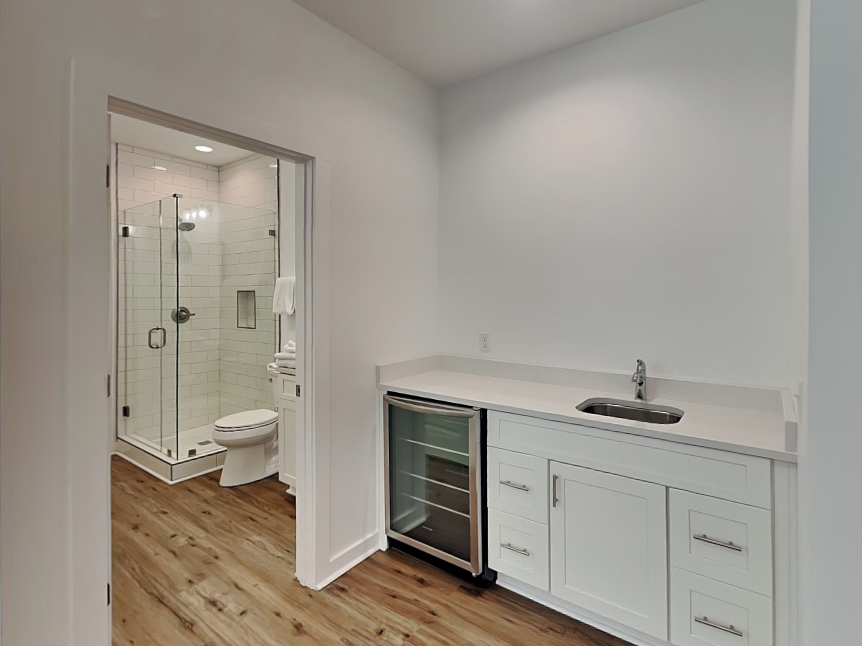 Une salle de bain moderne avec une douche à parois de verre, des toilettes et un lavabo avec un meuble de rangement.