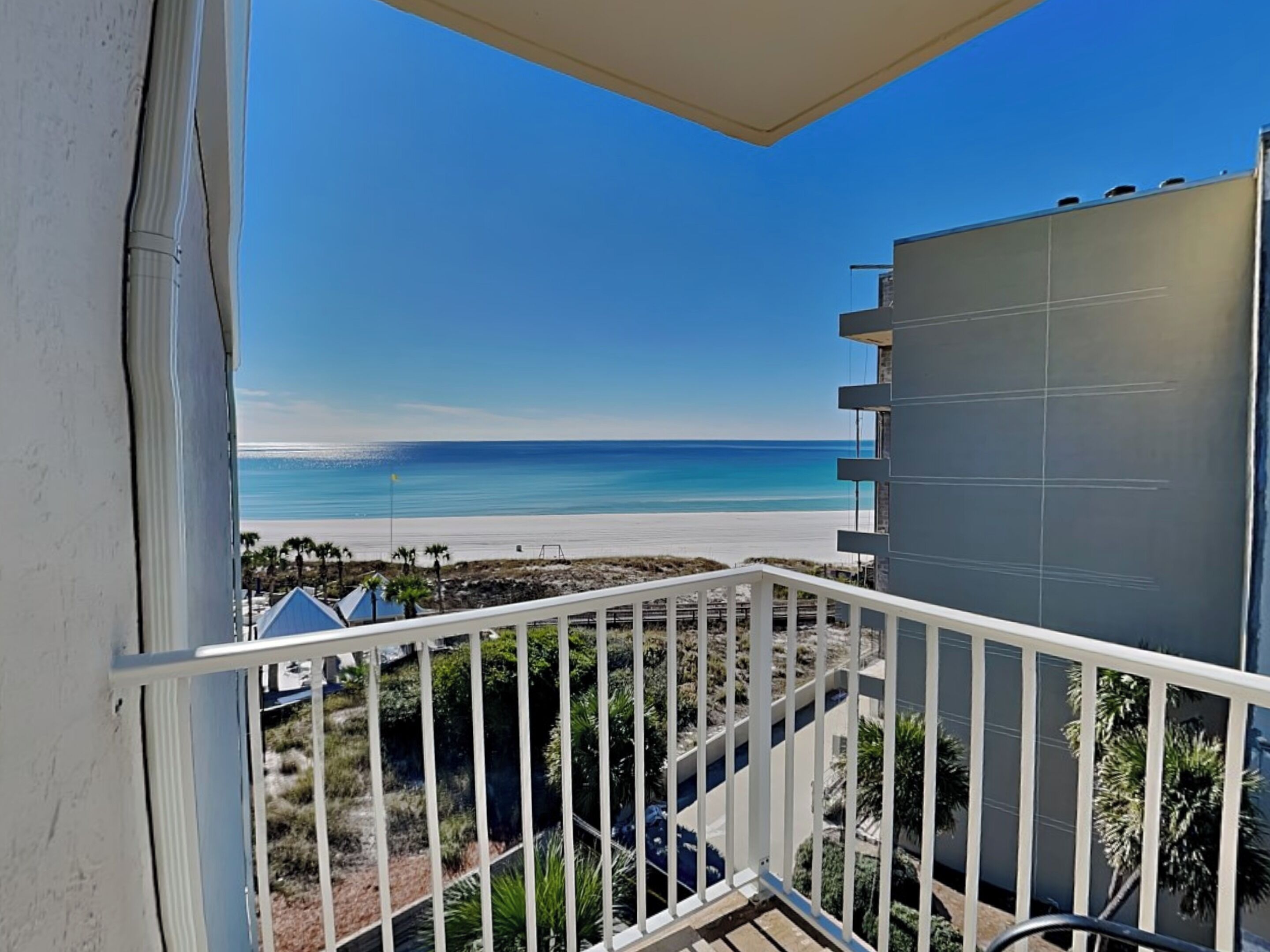 A balcony with a view of a beach and ocean.